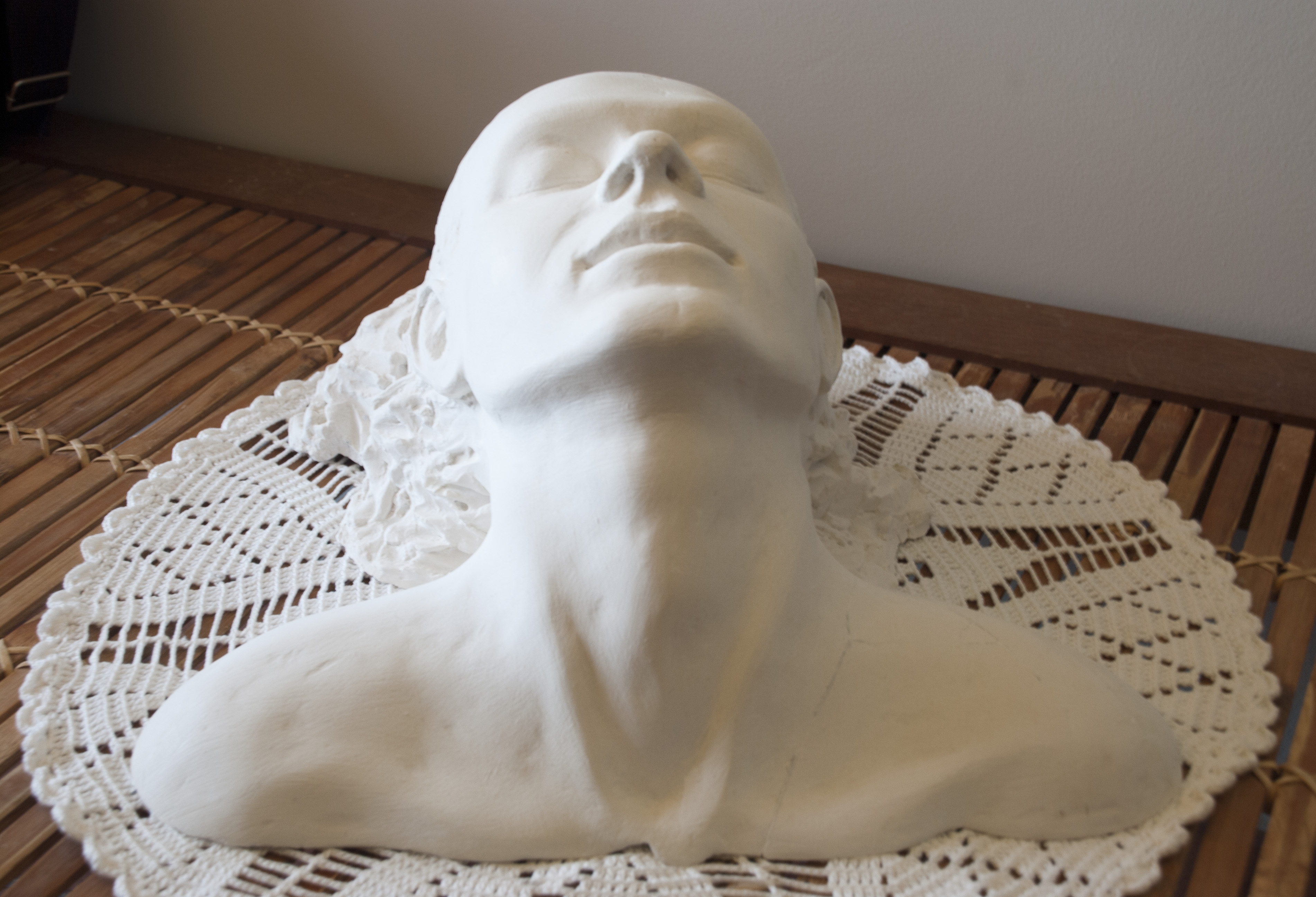 Del agua escultura de cabeza de mujer saliendo del agua